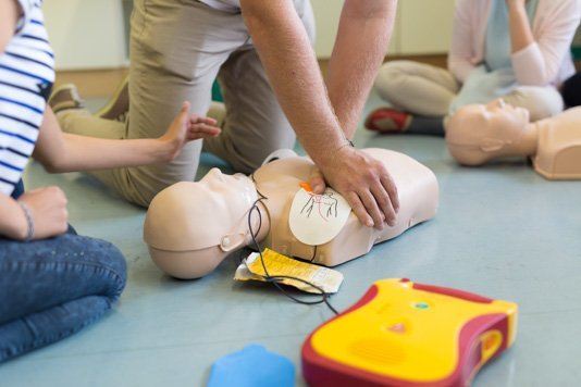 First Aiders practising CPR with a defibrillator during and AED training course